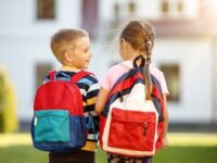 Children with backpacks going to the school. Concept of knowledge and studying.